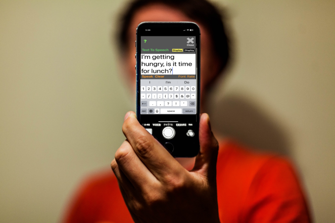 picture of a person holding an iPhone with text to speech