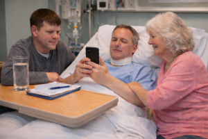 Adult patient in hospital using a smartphone to communicate with family